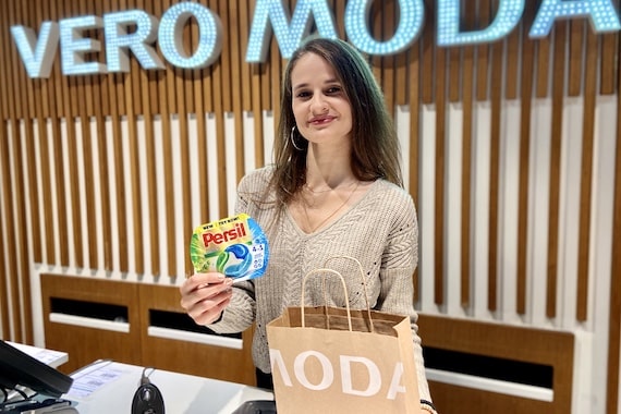 Verkäuferin im Modegeschäft Vero Moda mit Produktproben und Einkaufstasche