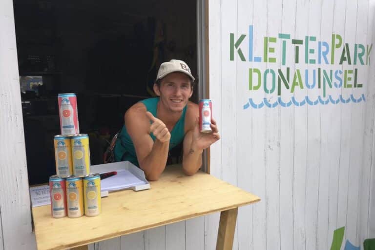 Mann mit Gasteiner Dosen am Tisch vor dem Kletterpark Donauinsel