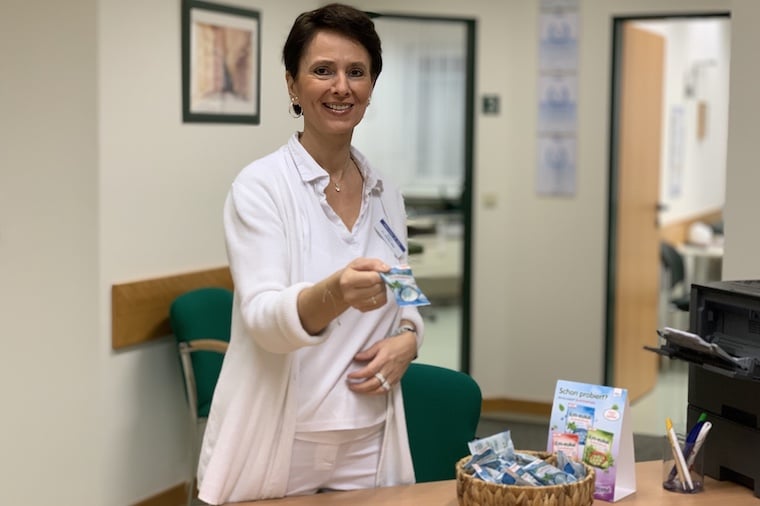 Frau in Arztpraxis hält em-eukal Packung
