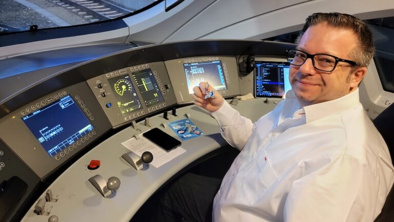 Mann im Führerstand eines Zuges hält eine Orbit Kaugummi Probe