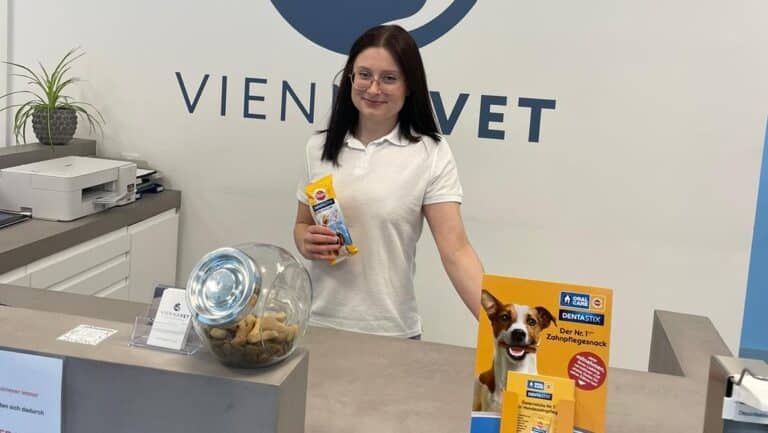 Frau mit Dentastix Probe am Empfang einer Tierarztpraxis