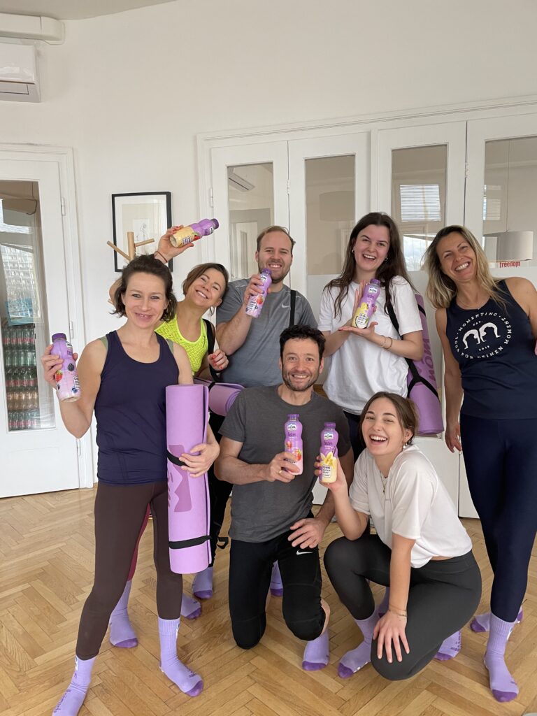 Gruppe mit Yogamatten und NÖM Fasten Flaschen im Premium Fitnesscenter