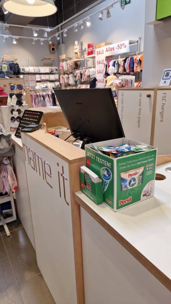 Verkaufstresen im Kindermodegeschäft mit Persil Produktproben
