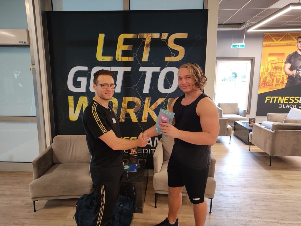 Zwei Studenten erhalten im Fitnessstudio eine NUYU Nuts Produktprobe