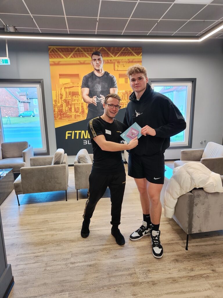 Zwei junge Männer mit Produktprobe im Fitnessstudio
