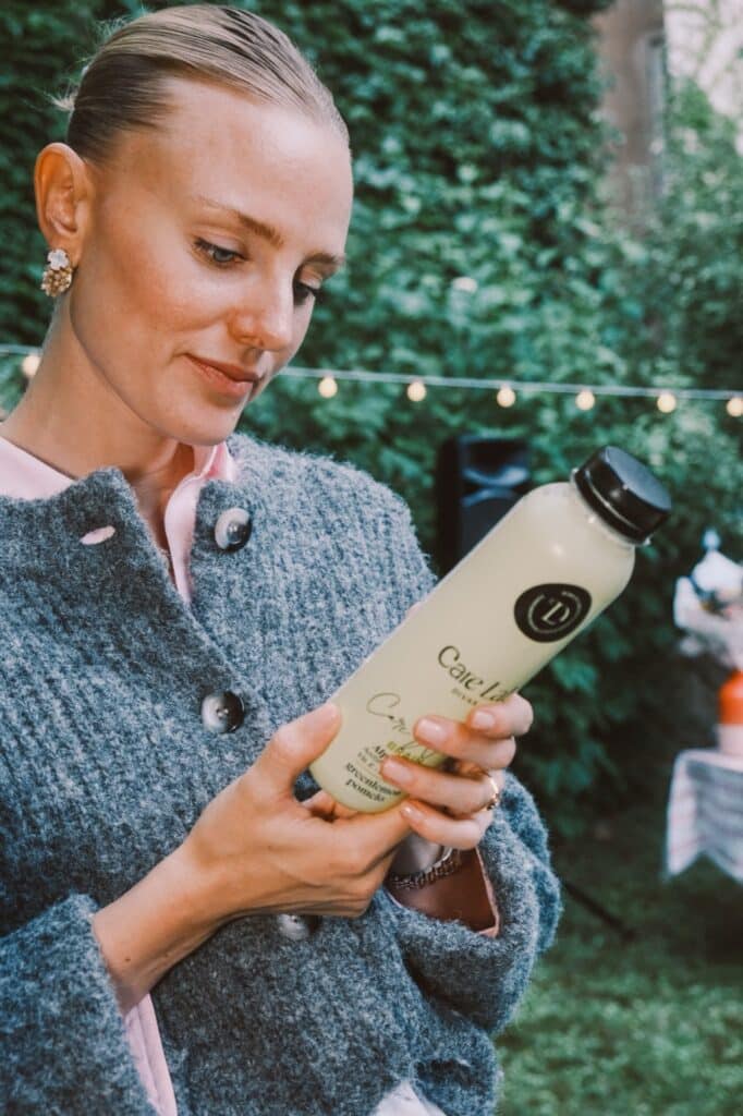 Junge Frau erhält bei einer Gartenparty eine Care Water Produktprobe