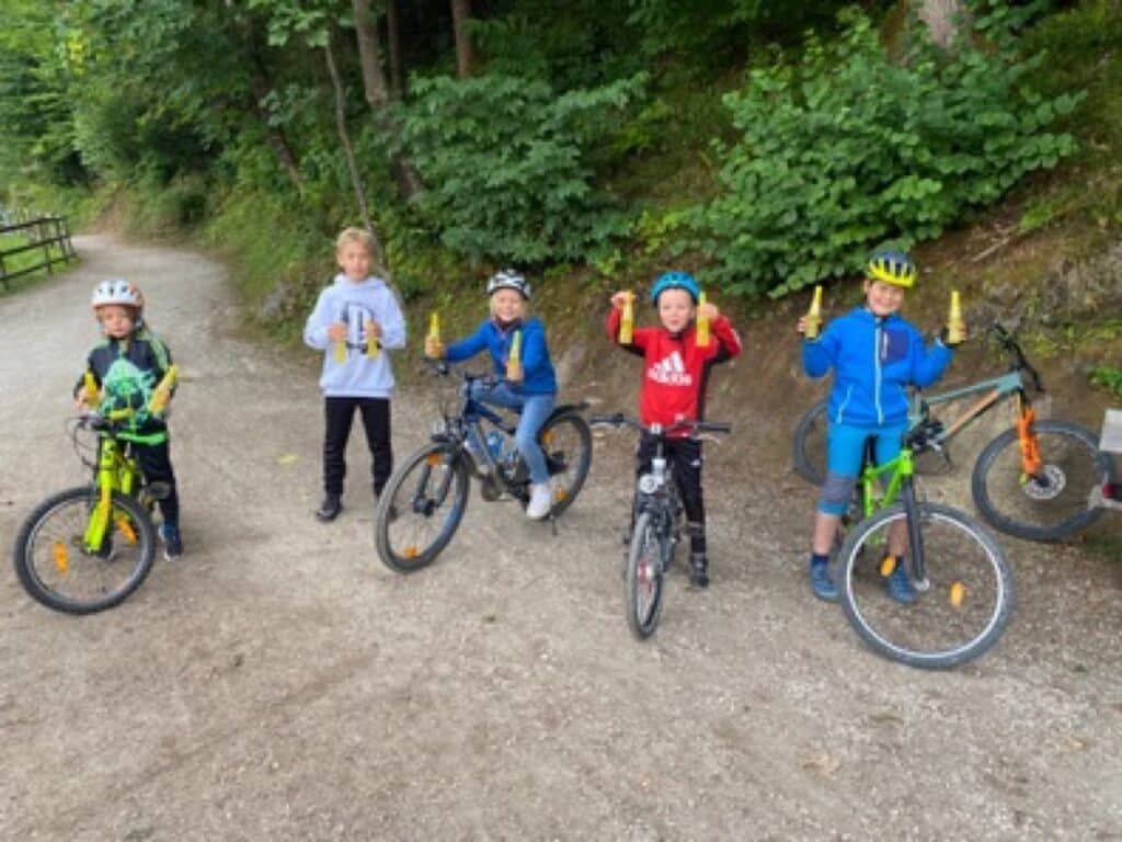 Kinder auf Mountainbikes mit Dreh und Trink Produktproben im Urlaub
