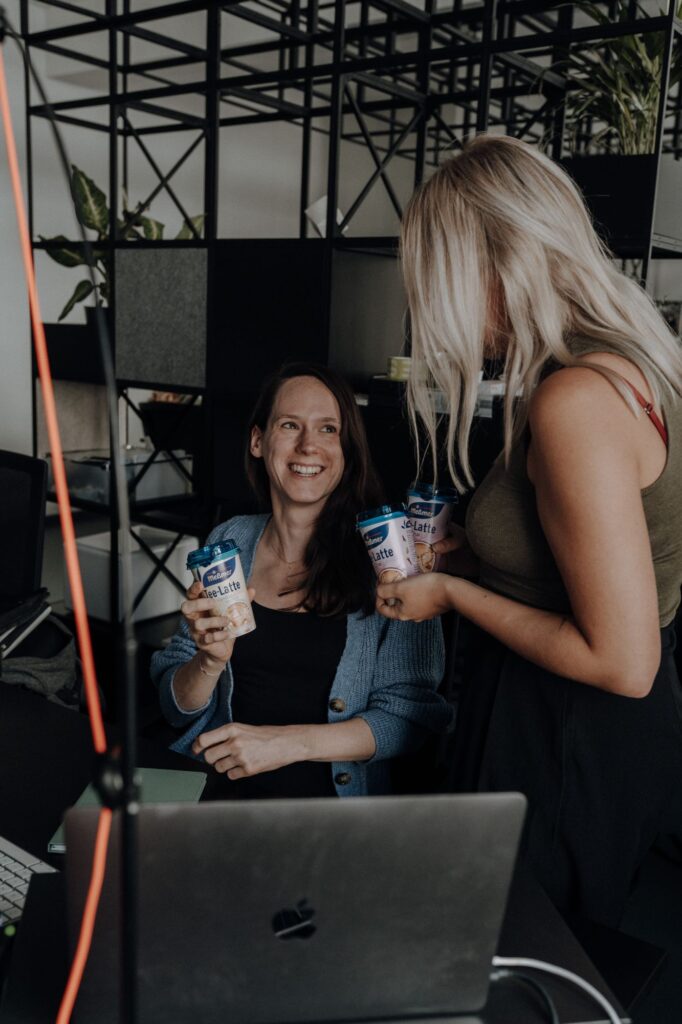 Zwei Frauen mit Meßmer Tee-Latte im Büro, Sampling über Freudebringer
