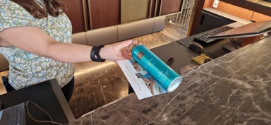 Hände halten ein blaues Produkt auf einem Holztisch