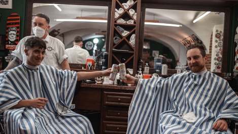 Zwei Männer mit Friseurumhang im Barbershop